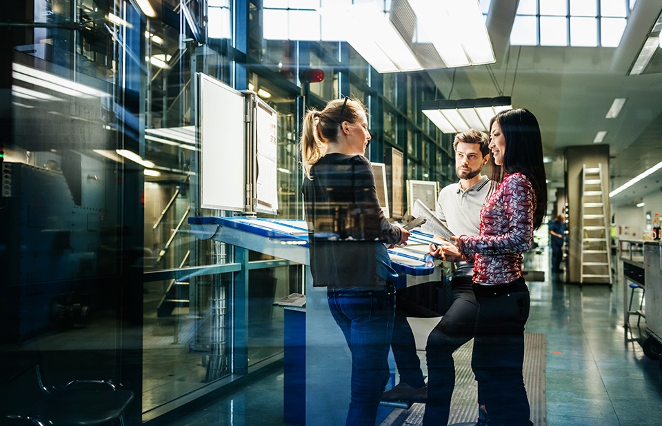 Team of three standing around a table working